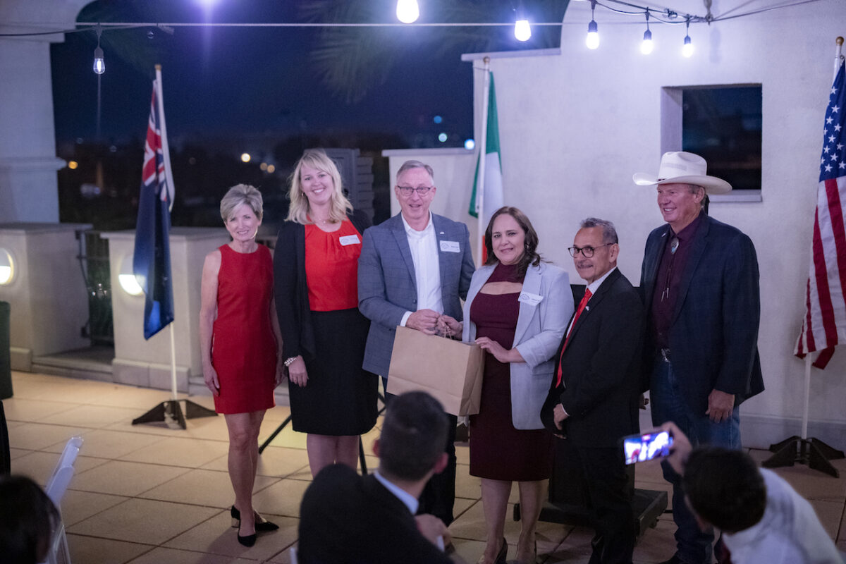 Six people standing up at an event outside being recognized.