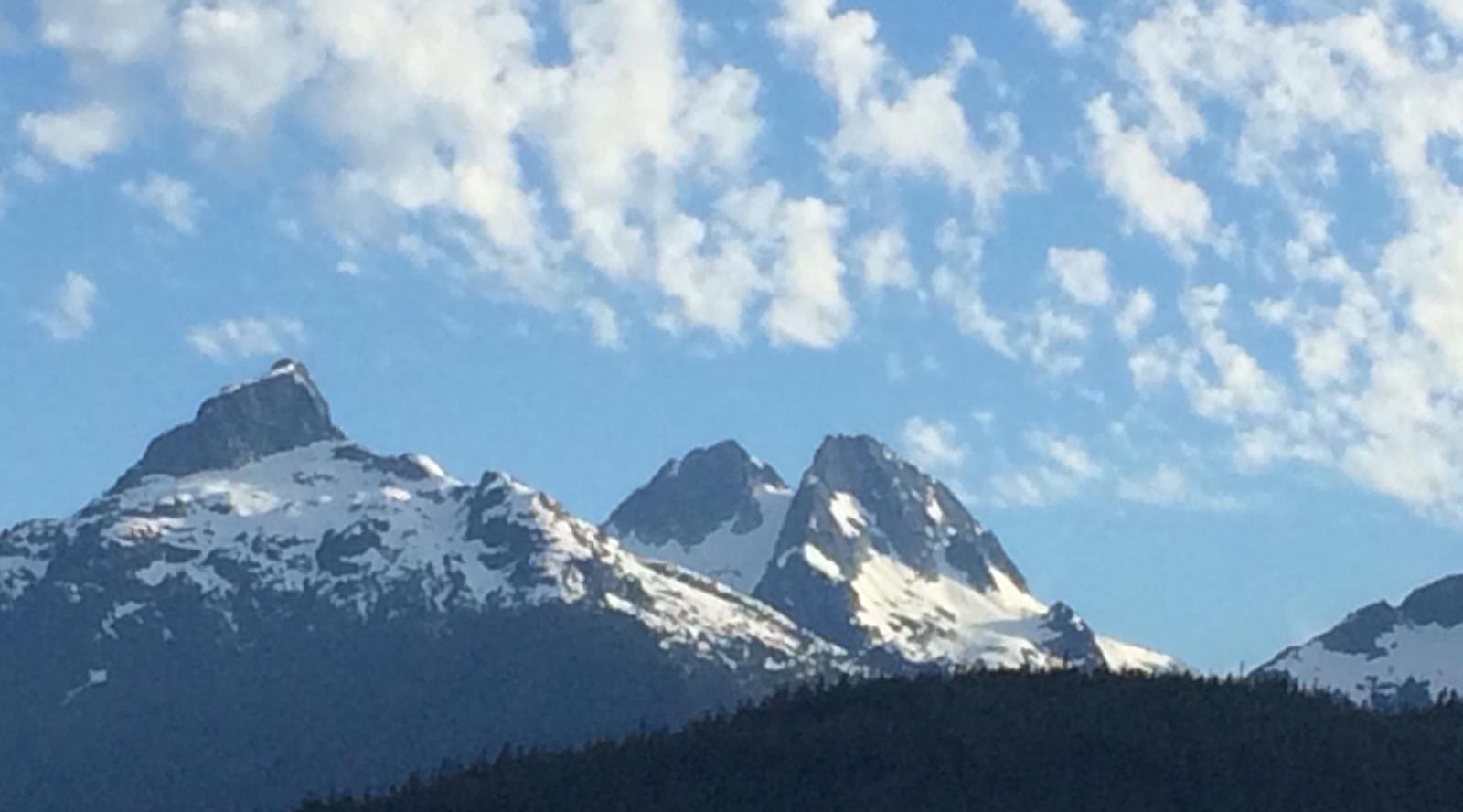 Snowcapped mountains with blue sky and clouds near Burnaby, Canada.