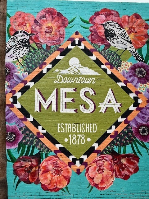 Mural on the side of a building in downtown Mesa Arizona showing a mandala with the words Mesa, establised 1878